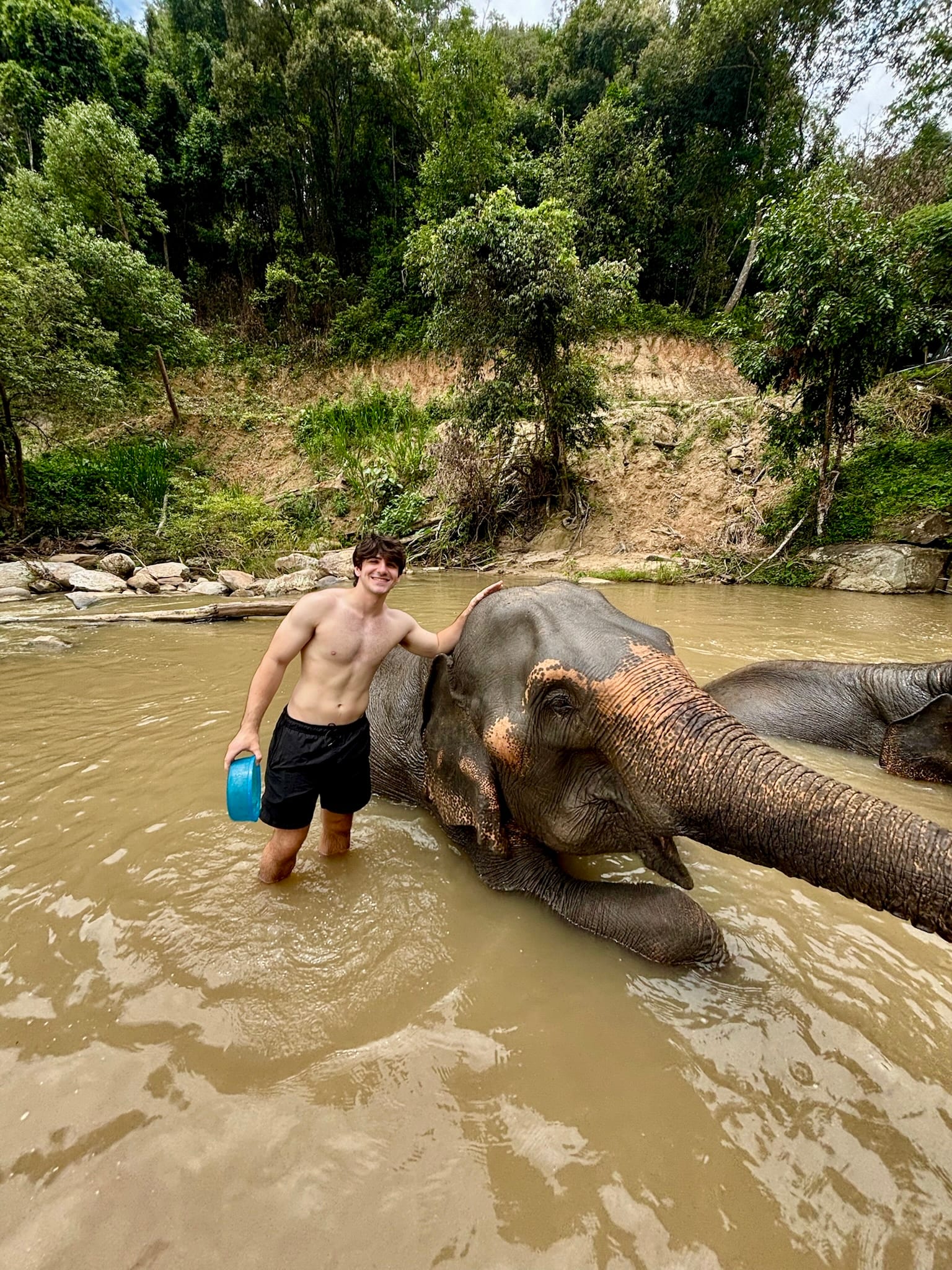 Standing beside an elephant in a river